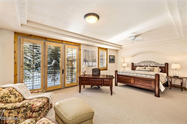 carpeted bedroom featuring a raised ceiling and access to outside