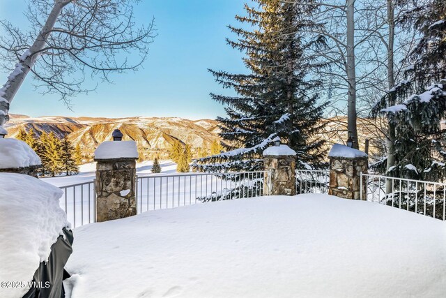 yard layered in snow featuring a mountain view