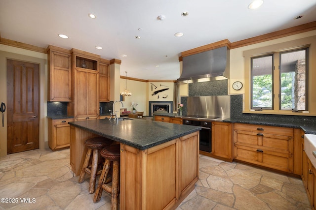2005 Wildwood Rd, Avon, CO 81620 - kitchen featuring wall chimney range hood, black appliances, stone tile floors, recessed lighting, and decorative backsplash