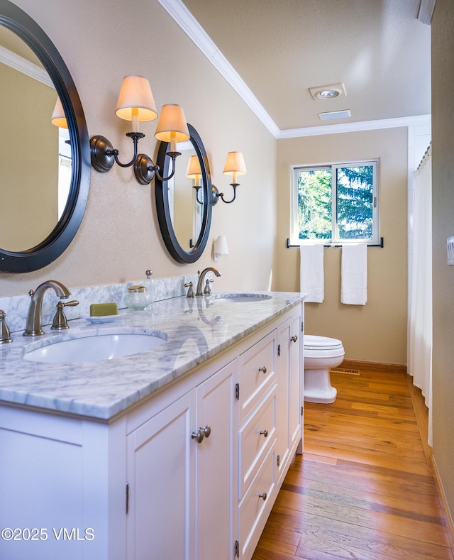 130 Morgan Dr Unit B, Edwards, CO 81632 - bathroom featuring ornamental molding, double vanity, toilet, wood finished floors, and baseboards