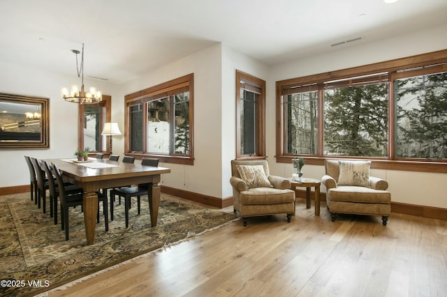 dining area featuring light hardwood / wood-style floors and a notable chandelier