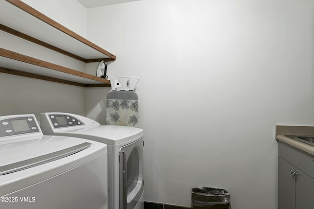 laundry room featuring cabinets and washing machine and dryer