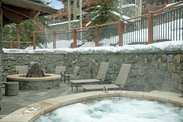 snow covered pool with a patio area and a fire pit