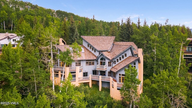 60 Elk Track Ct, Beaver Creek, CO 81620 - back of property featuring a forest view, stucco siding, and a balcony