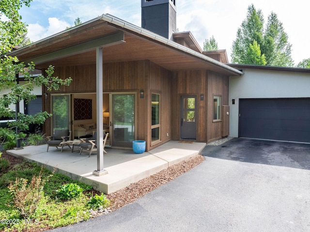 232 Stetson Dr, Edwards, CO 81632 - property entrance with asphalt driveway, a chimney, and a garage