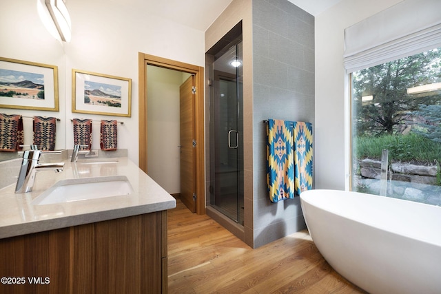 232 Stetson Dr, Edwards, CO 81632 - full bath featuring double vanity, wood finished floors, a shower stall, and a freestanding bath