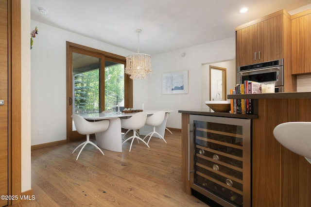 232 Stetson Dr, Edwards, CO 81632 - dining area with beverage cooler, light wood-type flooring, and a chandelier