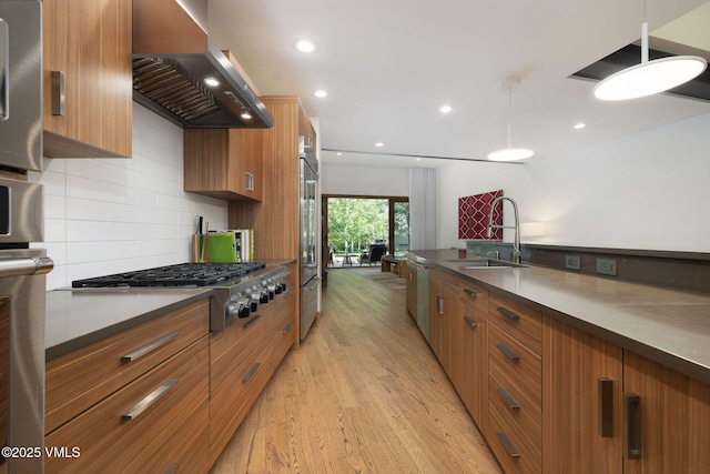 232 Stetson Dr, Edwards, CO 81632 - kitchen featuring wall chimney exhaust hood, stainless steel appliances, brown cabinetry, dark countertops, and recessed lighting