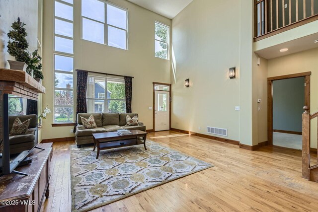 41 Wren Ct, Eagle, CO 81631 - living room featuring wood-type flooring, a towering ceiling, baseboards, and a fireplace with raised hearth