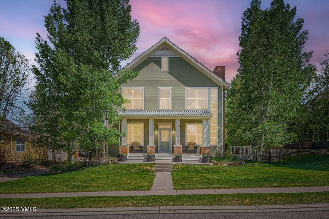 41 Wren Ct, Eagle, CO 81631 - view of front of house featuring a porch, a front yard, a chimney, and brick siding