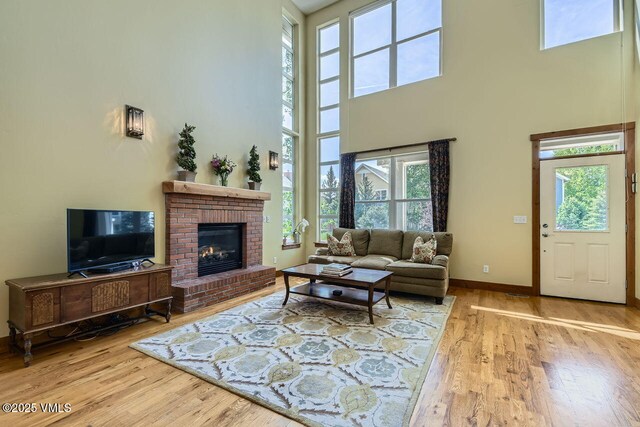41 Wren Ct, Eagle, CO 81631 - living room with a high ceiling, wood finished floors, a brick fireplace, and baseboards