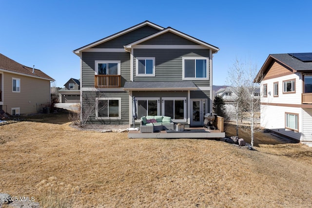 back of property with a balcony and outdoor lounge area