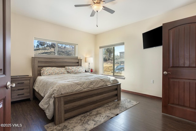 bedroom featuring baseboards, wood finished floors, and a ceiling fan