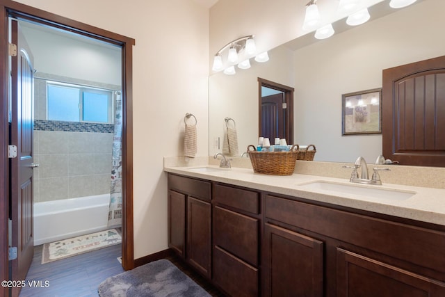 bathroom featuring double vanity, shower / tub combo, baseboards, and a sink