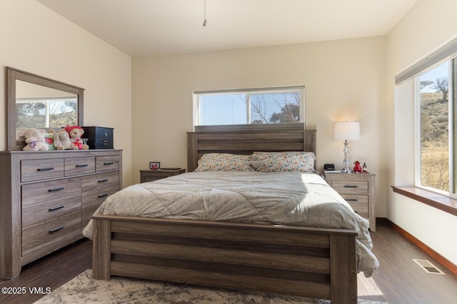 bedroom with visible vents, baseboards, and dark wood finished floors