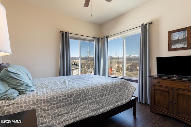 bedroom featuring multiple windows, dark wood-type flooring, and ceiling fan