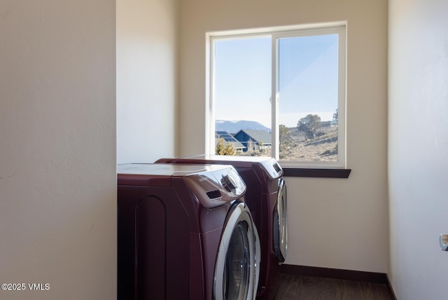 laundry room featuring laundry area, wood finished floors, baseboards, and washing machine and clothes dryer