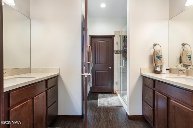 full bathroom with wood finished floors, a stall shower, and a sink