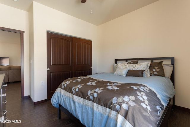 bedroom featuring a ceiling fan, dark wood-style floors, baseboards, and a closet