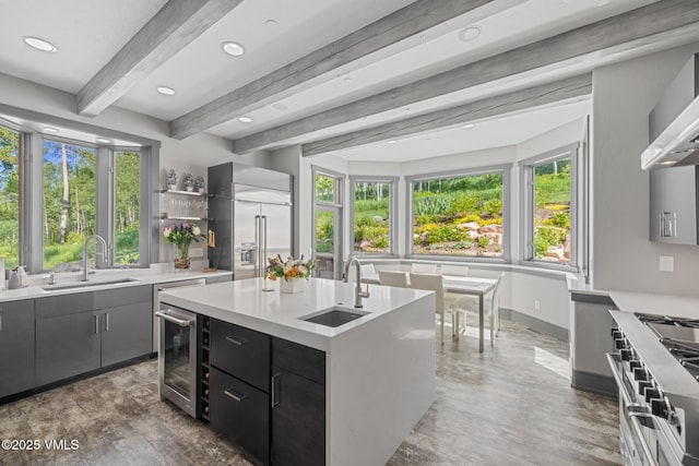 25 W Timber Draw Dr, Edwards, CO 81632 - kitchen featuring wine cooler, premium appliances, light countertops, beam ceiling, and a center island with sink