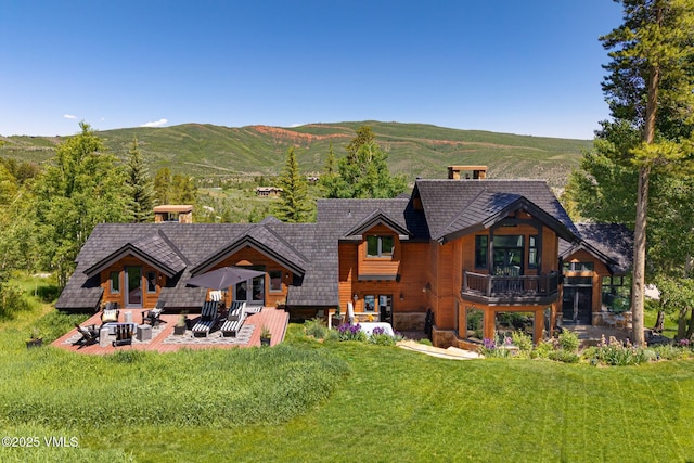 25 W Timber Draw Dr, Edwards, CO 81632 - back of property with a mountain view, a chimney, a patio area, a lawn, and a balcony