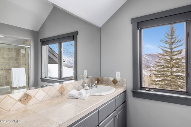 25 W Timber Draw Dr, Edwards, CO 81632 - full bathroom featuring vanity, vaulted ceiling, tiled shower, and plenty of natural light