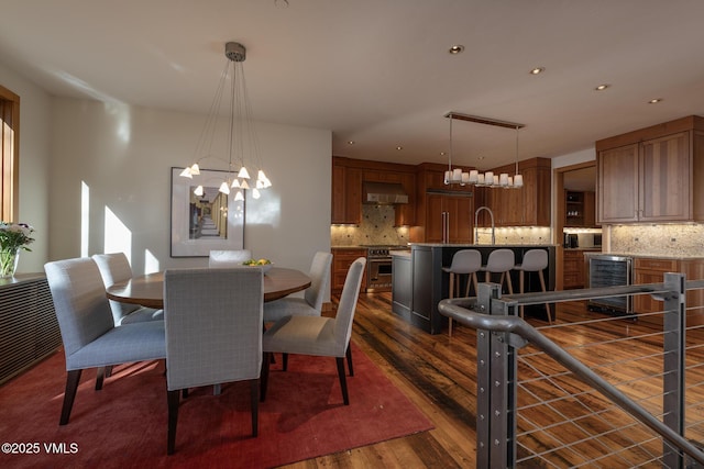 dining space featuring wine cooler, dark wood finished floors, a notable chandelier, and recessed lighting