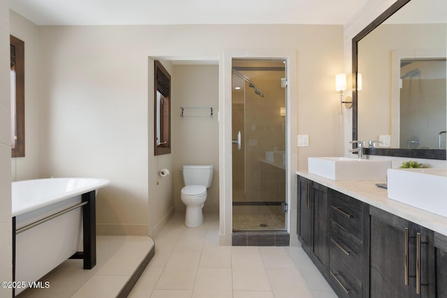 full bath featuring double vanity, a stall shower, a sink, and toilet