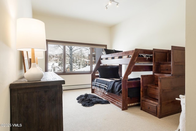 bedroom with rail lighting, a baseboard radiator, and light colored carpet