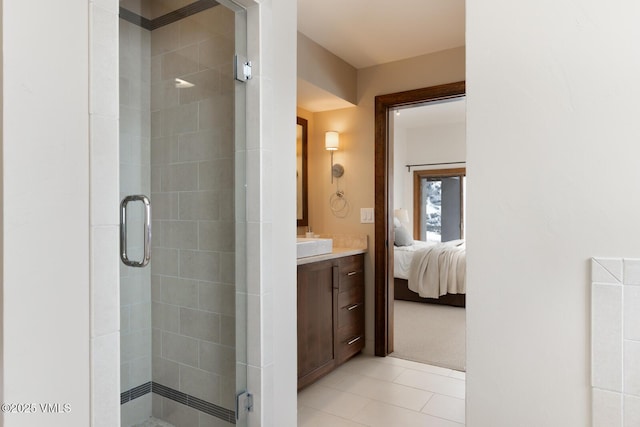 ensuite bathroom featuring ensuite bathroom, tile patterned flooring, a shower stall, and vanity