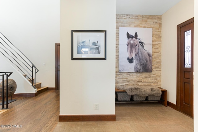 entryway with stairs, baseboards, and wood finished floors