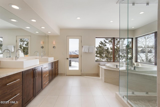 bathroom featuring a garden tub, double vanity, a sink, and recessed lighting