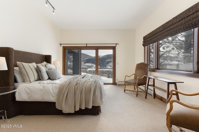 bedroom with baseboards, light colored carpet, rail lighting, access to outside, and a mountain view