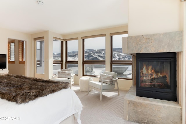 bedroom featuring carpet floors, a fireplace, and a mountain view