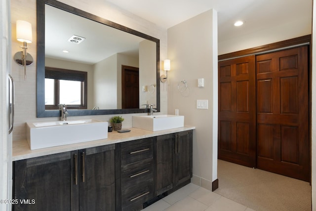 bathroom with double vanity, a closet, visible vents, and a sink