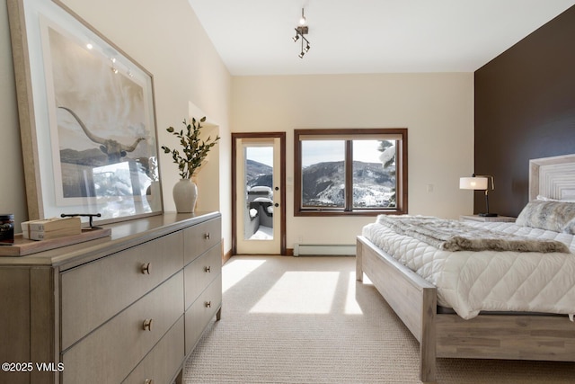 bedroom with access to exterior, a baseboard radiator, rail lighting, and light colored carpet