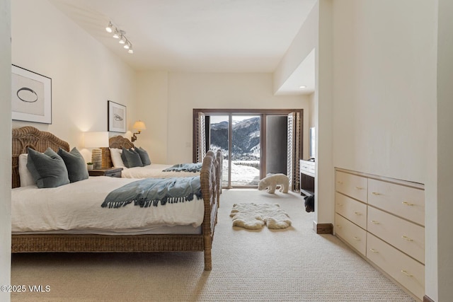 bedroom with light carpet and track lighting