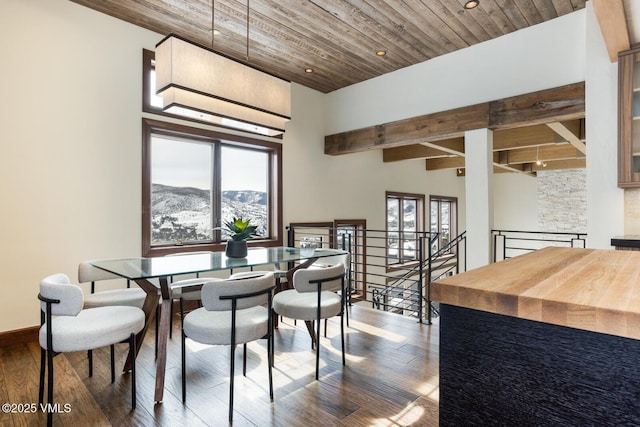 dining area featuring a mountain view, a high ceiling, wood finished floors, wood ceiling, and baseboards