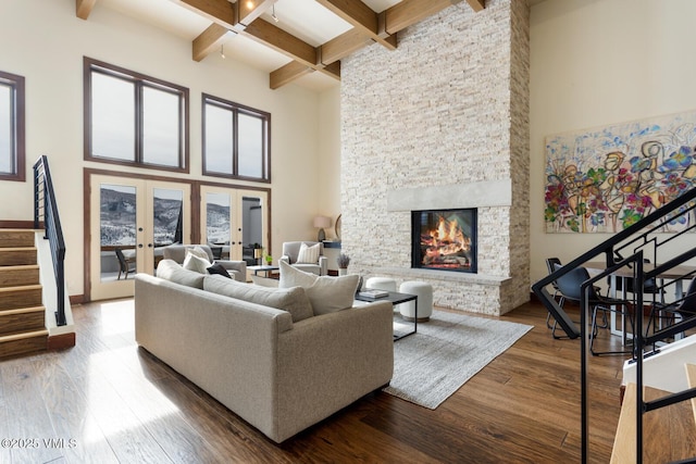 living room featuring french doors, a fireplace, stairway, and wood finished floors