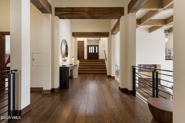 hall with an upstairs landing, baseboards, dark wood-style flooring, and beamed ceiling