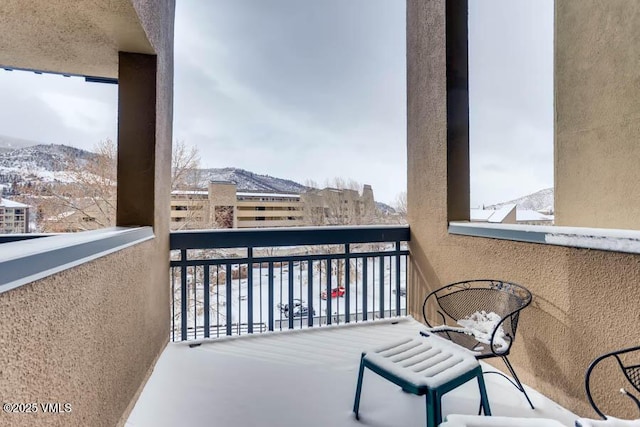 snow covered back of property with a mountain view