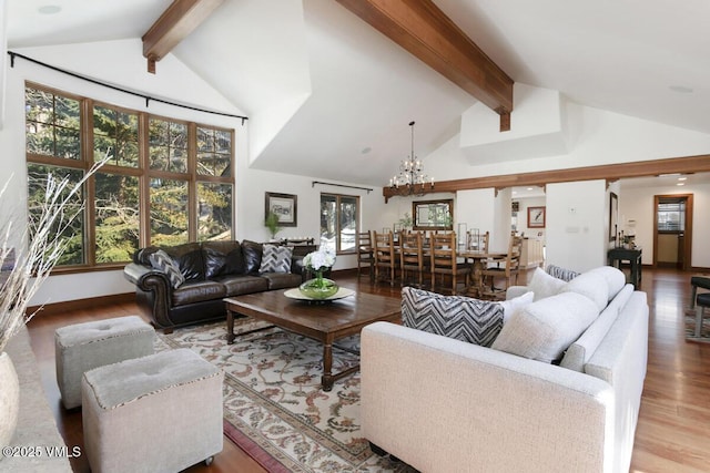 living area with beam ceiling, a notable chandelier, wood finished floors, and high vaulted ceiling