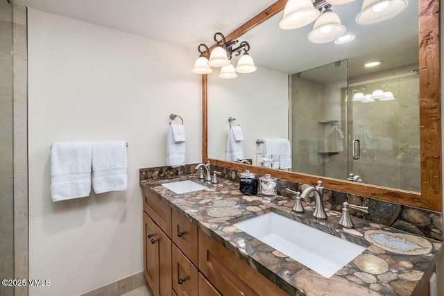 full bath with double vanity, a shower stall, baseboards, and a sink