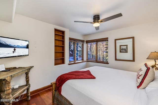 bedroom with ceiling fan, baseboards, and wood finished floors