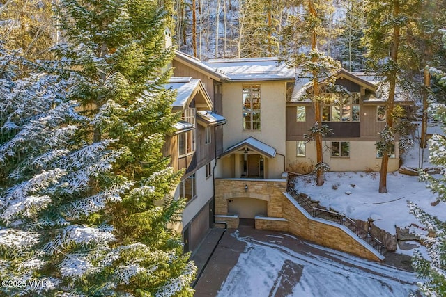 view of front of house featuring stone siding and stucco siding