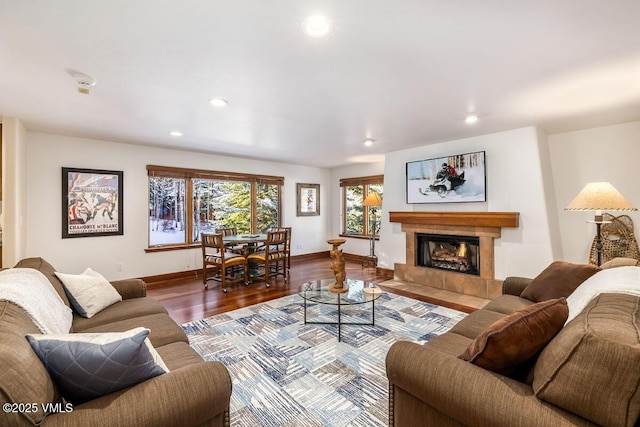 living area featuring recessed lighting, a fireplace, baseboards, and wood finished floors