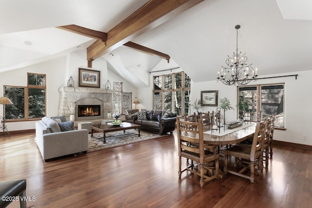 dining room featuring lofted ceiling with beams, baseboards, a glass covered fireplace, and dark wood-style flooring