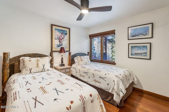 bedroom featuring a ceiling fan, baseboards, and wood finished floors