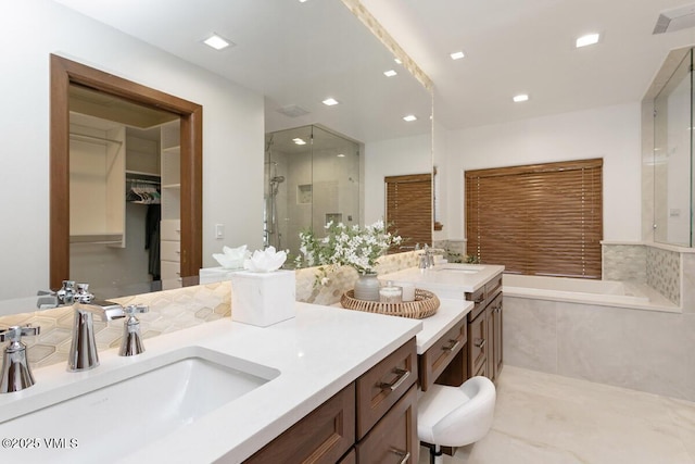 bathroom with vanity, recessed lighting, a stall shower, a walk in closet, and a garden tub