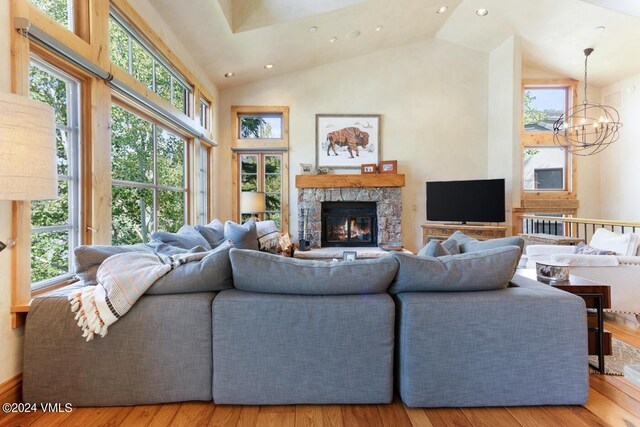 living room with high vaulted ceiling, light hardwood / wood-style flooring, and a wealth of natural light